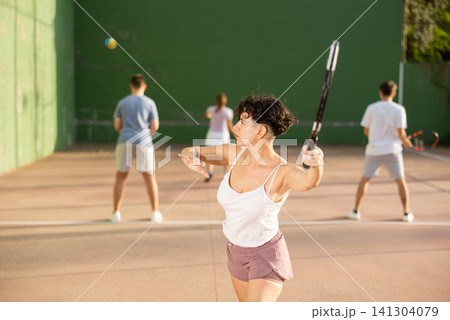 Woman playing frontenis on outdoor pelota court Woman playing frontenis on outdoor pelota court 141304079