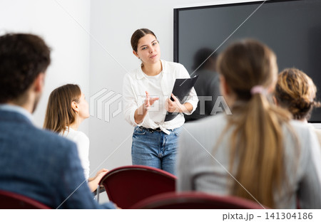 Young female teacher giving lecture to group of student Young female teacher giving lecture to group of student 141304186