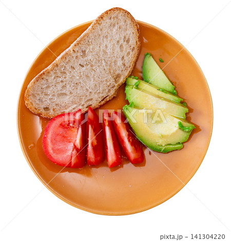 Fresh sliced avocado and tomato arranged on plate 141304220