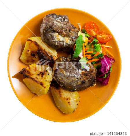 Pork cheek served with potatoes and vegetable salad Pork cheek served with potatoes and vegetable salad 141304258