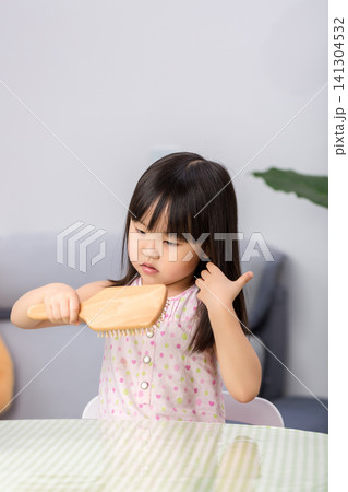 Little Asian Girl Brushing Hair at Home, Child Self Care Routine and Daily Hygiene Concept Little Asian Girl Brushing Hair at Home, Child Self Care Routine and Daily Hygiene Concept 141304532