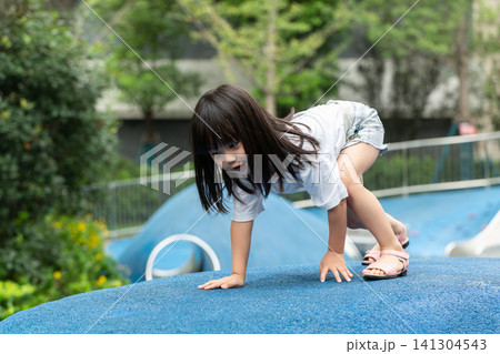 Asian Little Girl Climbing Wall at Outdoor Playground Asian Little Girl Climbing Wall at Outdoor Playground 141304543