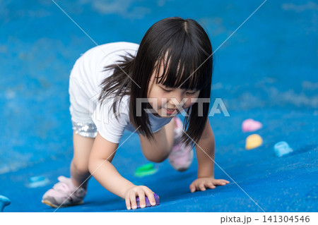 Asian Little Girl Climbing Wall at Outdoor Playground Asian Little Girl Climbing Wall at Outdoor Playground 141304546