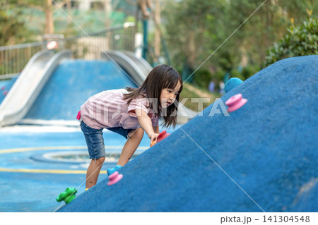 Asian Little Girl Climbing Wall at Outdoor Playground Asian Little Girl Climbing Wall at Outdoor Playground 141304548