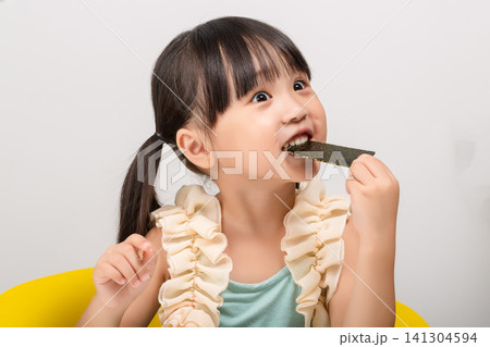 Happy Asian kid holding a piece of seaweed snack, healthy dried seaweed concept for children. 141304594