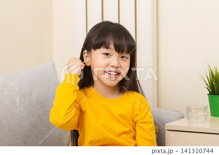 Asian girl cleaning ear with cotton swab child hygiene healthcare concept Asian girl cleaning ear with cotton swab child hygiene healthcare concept 141310744