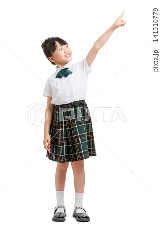 Cute primary student standing in uniform and pointing her finger up to the sky. Cute primary student standing in uniform and pointing her finger up to the sky. 141310779