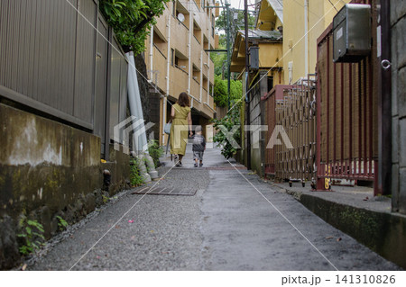 雨上がりの路地裏の細い道を散策する親子 雨上がりの路地裏の細い道を散策する親子 141310826