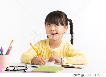 Asian schoolgirl showing various emotions while doing homework, feeling confused, inspired, and excited. Asian schoolgirl showing various emotions while doing homework, feeling confused, inspired, and excited. 141311598