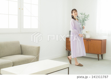 リビングで花瓶を持つ女性 リビングで花瓶を持つ女性 141311787