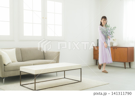 リビングで花瓶を持つ女性 リビングで花瓶を持つ女性 141311790