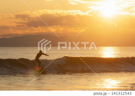 湘南鵠沼海岸 夕陽色に輝く海でサーフィン 湘南鵠沼海岸 夕陽色に輝く海でサーフィン 141312543