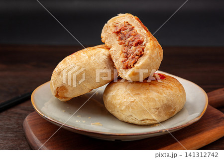 crispy layered meat pie broken open to show juicy beef filling, traditional Asian street food. crispy layered meat pie broken open to show juicy beef filling, traditional Asian street food. 141312742