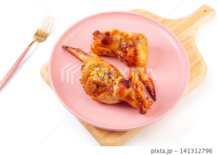 taiwanese style roasted chicken wing stuffed with flavorful fried rice, cut open and served on plate. taiwanese style roasted chicken wing stuffed with flavorful fried rice, cut open and served on plate. 141312796