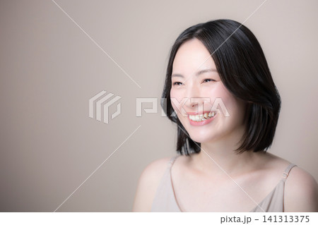 ピンクベージュ背景笑顔の美しい日本人女性 美しい素肌とナチュラルメイクの美容見上げる笑顔 ピンクベージュ背景笑顔の美しい日本人女性 美しい素肌とナチュラルメイクの美容見上げる笑顔 141313375