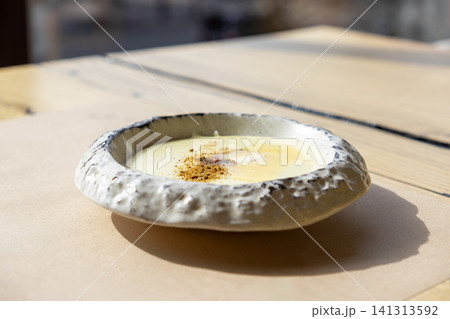 Creamy mashed potatoes with melted cheese and spice garnish served in a rustic ceramic bowl on a wooden table, capturing the savory essence of gourmet comfort food for menu design Creamy mashed potatoes with melted cheese and spice garnish served in a rustic ceramic bowl on a wooden table, capturing the savory essence of gourmet comfort food for menu design 141313592