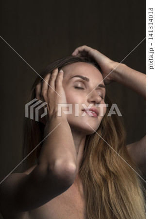 portrait of a young beautiful woman on a dark background 141314018