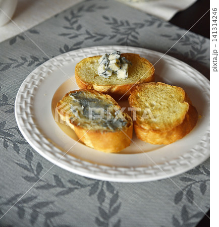 Blue cheese on baguette on white plate. 141314246