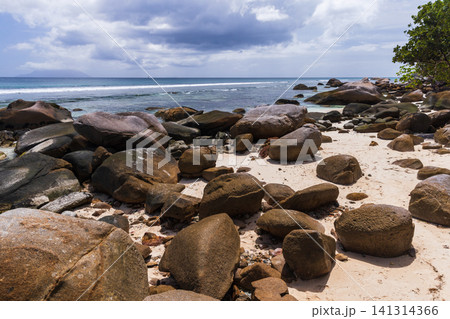 Tropical beach scene featuring large boulders and ocean water. Seychelles 141314366