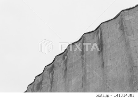 Concrete old building architecture structure cement facade apartment stone with elements of illumination bulbs on the roof against a background of gray sky 141314393