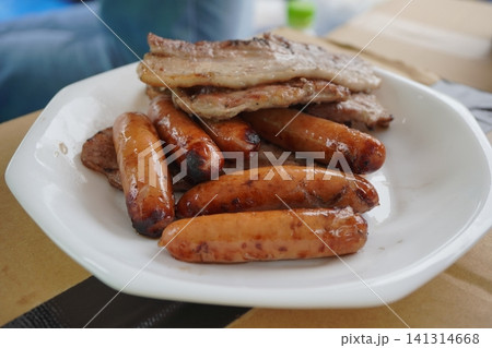 バーベキューで焼いたソーセージと豚肉の盛り合わせ バーベキューで焼いたソーセージと豚肉の盛り合わせ 141314668