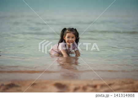 happy preschool child girl playing water on sea beach in Pattaya, Thailand happy preschool child girl playing water on sea beach in Pattaya, Thailand 141314908