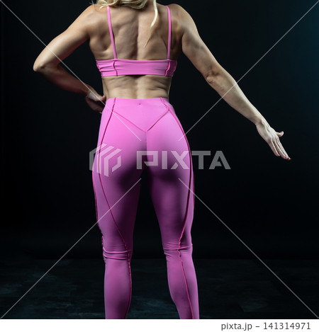 athletic female body in pink sportswear on dark background, fitness woman, athletic girl torso athletic female body in pink sportswear on dark background, fitness woman, athletic girl torso 141314971