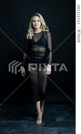 Young blonde dancer wearing transparent black dress and high heels posing in studio with black background Young blonde dancer wearing transparent black dress and high heels posing in studio with black background 141315182