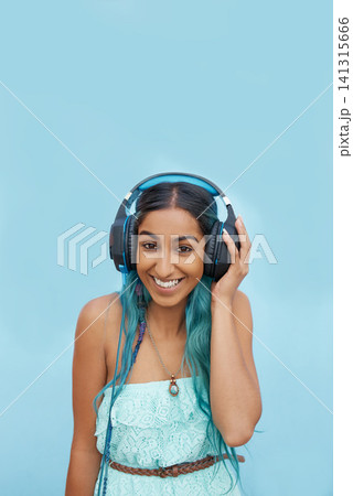 Headphones, smile and portrait of girl in studio with audio for music streaming, online radio or podcast. Indian student, happy and person with tech for media, sound and connection on blue background 141315666