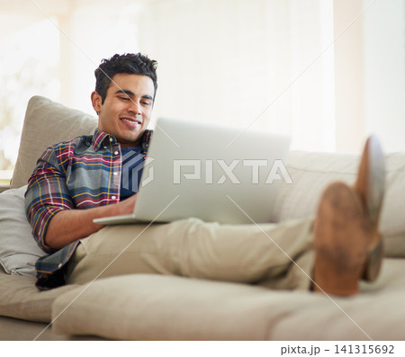 Man, laptop and home for internet connection with streaming service for free time, stress relief or resting. Male person, smile and couch with technology for online subscription, watching or blogging Man, laptop and home for internet connection with streaming service for free time, stress relief or resting. Male person, smile and couch with technology for online subscription, watching or blogging 141315692