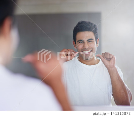 Smile, mirror and man with floss in bathroom for dental hygiene, gum disease and oral care. Health, happy and person in reflection after brushing teeth for wellness, cleaning and fresh breath in home Smile, mirror and man with floss in bathroom for dental hygiene, gum disease and oral care. Health, happy and person in reflection after brushing teeth for wellness, cleaning and fresh breath in home 141315872