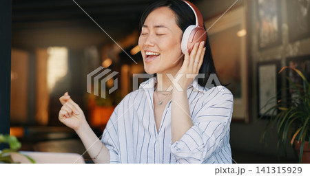 Happy asian woman, headphones and listening to playlist music in cafe for audio streaming, dancing or singing. Female person or freelancer smile or enjoying podcast, sound or song at coffee shop or r Happy asian woman, headphones and listening to playlist music in cafe for audio streaming, dancing or singing. Female person or freelancer smile or enjoying podcast, sound or song at coffee shop or r 141315929