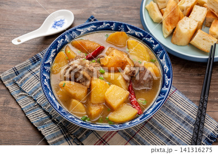 hearty Stewed Pork Bones with Potatoes and Chili Peppers in Rich Broth hearty Stewed Pork Bones with Potatoes and Chili Peppers in Rich Broth 141316275