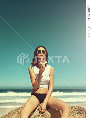 Watermelon, travel and woman at beach on summer vacation, adventure or holiday with freedom in Mexico. Fruit, sunglasses and female person on rock by ocean and blue sky with mockup on weekend trip. 141316671