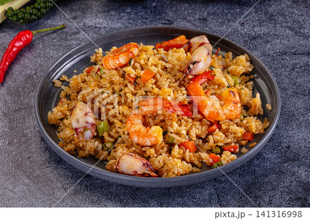 Seafood fried rice with shrimp and squid on dark plate Seafood fried rice with shrimp and squid on dark plate 141316998