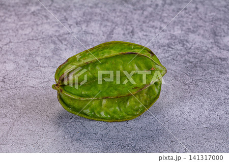 Green star fruit on textured gray surface Green star fruit on textured gray surface 141317000