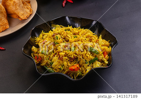 Spiced yellow rice with vegetables in black bowl Spiced yellow rice with vegetables in black bowl 141317189