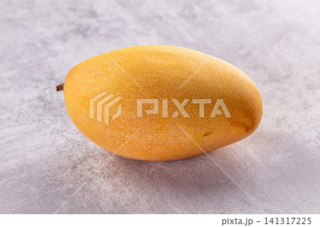 Ripe yellow mango on textured gray surface Ripe yellow mango on textured gray surface 141317225
