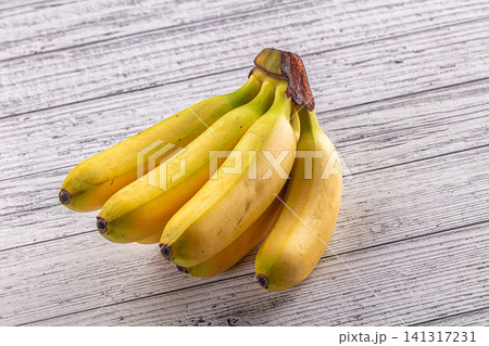 Fresh yellow bananas on rustic white wood surface Fresh yellow bananas on rustic white wood surface 141317231