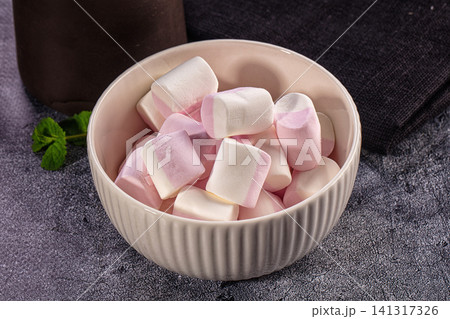 Pink and white marshmallows in ceramic bowl with mint leaf Pink and white marshmallows in ceramic bowl with mint leaf 141317326