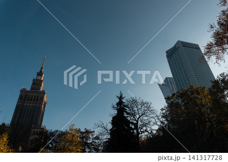 autumn central park with trees and skyscraper on background, blue sky autumn central park with trees and skyscraper on background, blue sky 141317728