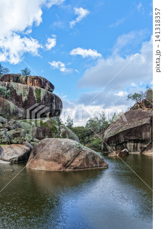 Aerial view of the natural rock pool, elevated viewing platform and striking granite rock formations at Cranky Rock Nature Reserve near Warialda, NSW. Carved by Reedy Creek Aerial view of the natural rock pool, elevated viewing platform and striking granite rock formations at Cranky Rock Nature Reserve near Warialda, NSW. Carved by Reedy Creek 141318357