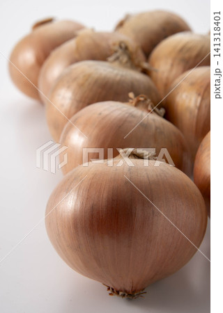白い背景に並んだ玉ねぎ、茶色い皮の新鮮な野菜の集合 141318401