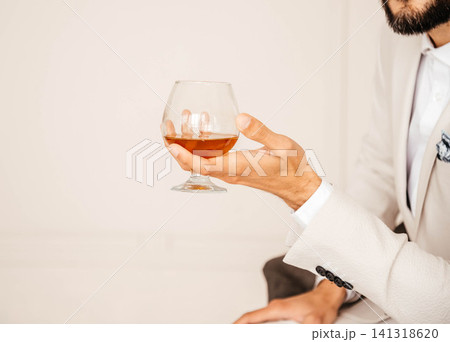 A glass of cognac in a man's hand. A glass of cognac in a man's hand. 141318620