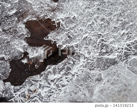 Broken Ice Sheet with Frost Crystal Patterns Over Dark Stone, Frosted Winter Nature Abstract Macro Broken Ice Sheet with Frost Crystal Patterns Over Dark Stone, Frosted Winter Nature Abstract Macro 141319213
