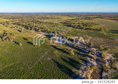 Aerial view of a creek winding through the lush green landscape surrounding the Pilliga Artesian Bore Baths, highlighting the natural beauty and peaceful bushland setting near Pilliga, NSW, Australia Aerial view of a creek winding through the lush green landscape surrounding the Pilliga Artesian Bore Baths, highlighting the natural beauty and peaceful bushland setting near Pilliga, NSW, Australia 141319243