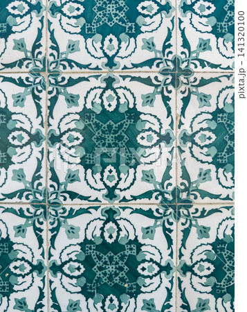 Close up of intricate green and white Portuguese azulejo tiles featuring a repeating floral and geometric pattern on a ceramic wall for classic architecture Close up of intricate green and white Portuguese azulejo tiles featuring a repeating floral and geometric pattern on a ceramic wall for classic architecture 141320100