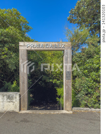 Wooden entrance gate with Praia da Luz sign surrounded by lush green trees in Foz, Porto, leading to a scenic seaside restaurant and terrace area Wooden entrance gate with Praia da Luz sign surrounded by lush green trees in Foz, Porto, leading to a scenic seaside restaurant and terrace area 141320103