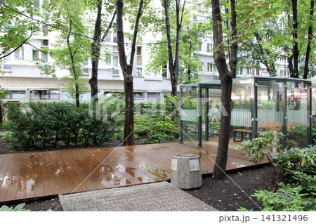 Modern glass smoking room on a wooden terrace in Warsaw park. 141321496