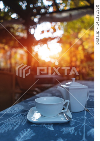 teapot with cup on table at park outdoor, fresh breakfast at sunset teapot with cup on table at park outdoor, fresh breakfast at sunset 141321550